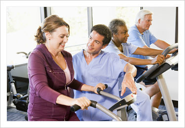 This is a picture of a physical therapist helping a patient on the indoor bike.
