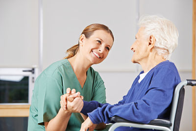This is a picture of a nurse holding a elderly patient hand.