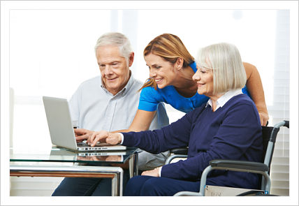 This is a picture of a nurse helping a elderly couple on a computer.