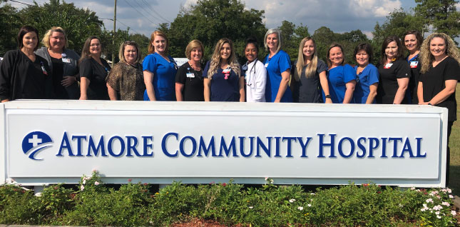 Atmore Community Hospital new sign with some of the staff standing behind the new sign.